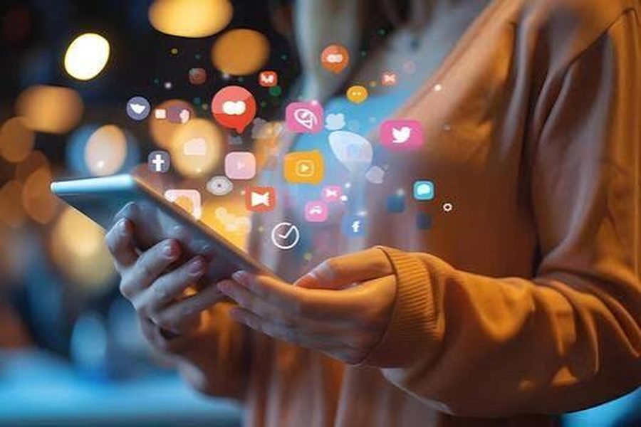 Person holding a tablet with social media icons floating above it